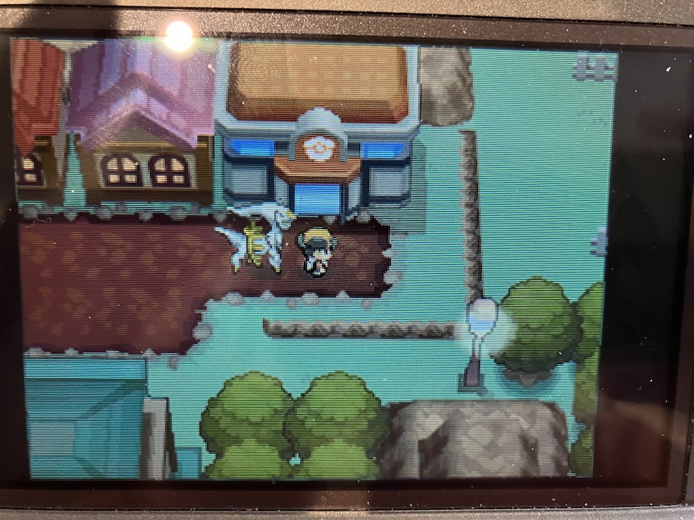 A photo of Pokemon HeartGold. An Arceus is following behind the player.
